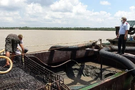 Lực lượng làm nhiệm vụ đo đạc lượng cát khai thác trái phép. Ảnh: Công an tỉnh Tiền Giang.