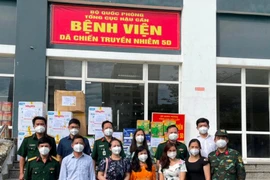 Bà Nguyễn Lê Vân, Phó Trưởng phòng Báo chí, Sở Thông tin - Truyền thông TPHCM, nhà báo Bùi Hương cùng các nhà hảo tâm trao quà tại Bệnh viện Dã chiến Truyền nhiễm số 5D.
