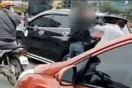 Tài xế áo đen liên tục lớn giọng chửi bậy và tát tài xế áo trắng sau va chạm giao thông. (Ảnh cắt từ clip)