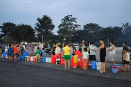 Trẻ nhỏ xách xô chậu theo người lớn xếp hàng chờ nước ở KĐT Thanh Hà