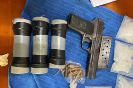 Súng K54 cùng 3 quả mìn tự chế thu giữ.