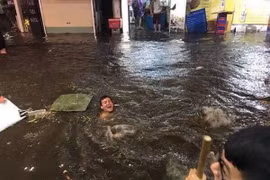 Du khách nước ngoài “chill” trong nước mưa ngập phố cổ