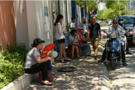 Phụ huynh “đội nắng” thấp thỏm chờ con bên ngoài phòng thi