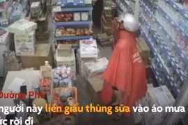 Video: Người phụ nữ lấy trộm thùng sữa rồi giấu vào áo mưa
