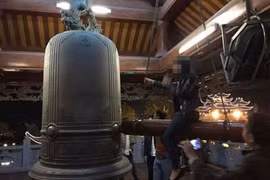 Cặp nam nữ ngồi lên cây dùi đánh chuông gây bức xúc