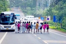 Nhóm phụ nữ dàn hàng ngang chụp ảnh giữa đường gây tranh cãi