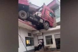 Container mất lái thản nhiên “đậu” trên nóc nhà dân