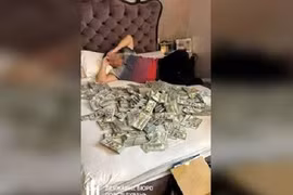 Một quan chức đang nằm trên đống tiền trong phòng thì bị bắt