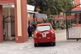 Học sinh đứng ở cổng trường chào giáo viên đi ô tô giữa trời lạnh giá