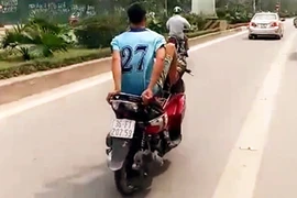 “Trẻ trâu” đầu trần lái xe máy bằng chân tại làn xe buýt BRT