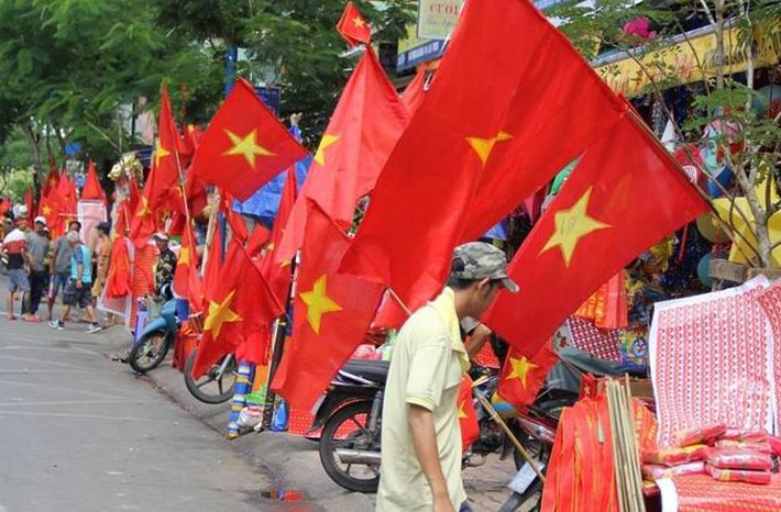 Phố phường rực rỡ cờ đỏ sao vàng chuẩn bị cho buổi chiều xung trận của các chàng trai bóng đá Việt Nam. Nhiều khách liên tục tấp xe vào các cửa hàng bên đường mua đồ cổ vũ cho đội bóng đá Việt Nam trước giờ "G".