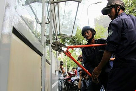 Nhân viên Dịch vụ công ích quận 1 đang phá cửa trụ sở khu phố 6 để dọn đồ ra trước khi phá bỏ