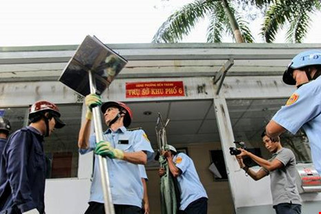 Lực lượng trật tự đô thị đang dọn đồ đạc bên trong trụ sở ra ngoài để phá dỡ