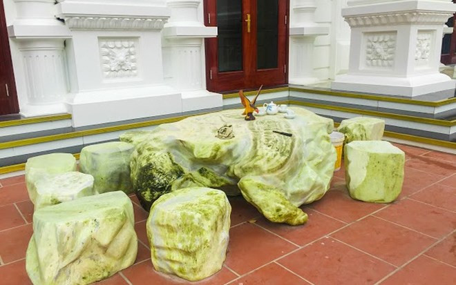 Bàn uống trà đặt ngay phía trước căn biệt thự. Trên bàn là hình đại bàng tung cánh.