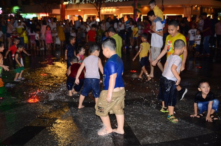Đêm trước lễ Giáng sinh 2018, trẻ em TP HCM tranh nhau tắm tại đài phun nước trên phố đi bộ Nguyễn Huệ.