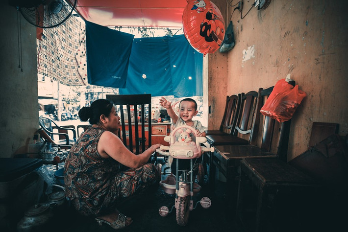Hai bà cháu bán hàng đang chơi khi vắng khách ở phố Gầm Cầu.