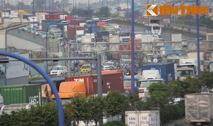 Xe máy phải chen chúc vào dòng xe tải, container để tìm đường thoát. Nguyên nhân kẹt xe được xác định do quá tải phương tiện vào cảng Cát Lái trong khi lượng xe từ khắp nơi đồng loạt đổ về đã gây tình trạng tắc nghẽn giao thông hết sức nghiêm trọng.