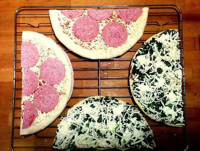 Trước khi cho pizza vào lò, bạn chỉ cần cắt đôi bánh. Mẹo vặt nhà bếp cực đơn giản này sẽ giúp bạn xếp được hai chiếc pizza vào nướng cùng một lúc. Ảnh: Bright.