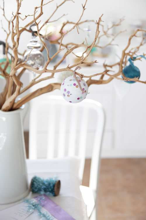 Thay vì trang trí nhà bằng cây thông Noel đắt tiền, hãy tìm một vài cành cây khô và cắm chúng vào một chiếc lọ, sau đó trang trí với những quả bóng lấp lánh sắc màu là không khí giáng sinh đã ngập tràn trong ngôi nhà của bạn rồi đó! Ảnh: Homesthetics.