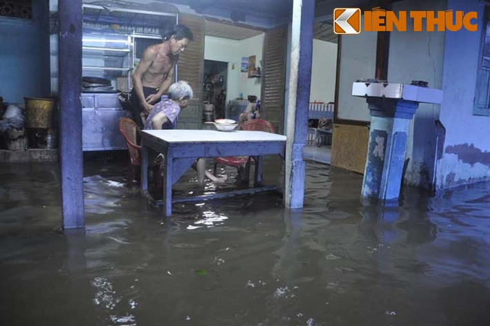 Hàng trăm nhà dân vô cùng khốn đớn khi phải huy động cả gia đình tìm đủ cách như chặn bao cát, tát nước, di dời tài sản để chống nước tràn vào nhà.