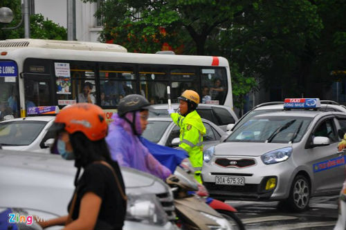 Vì thế, dù 4 cảnh sát cùng phân luồng nhưng nút giao Hoàng Minh Giám - Trần Duy Hưng vẫn hỗn loạn. Ảnh: Hoàn Nguyễn.