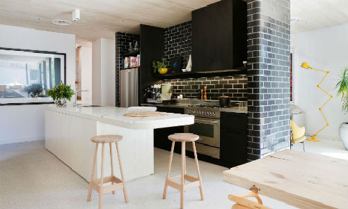 Nội thất bằng gỗ kết hợp gạch màu đậm mang đến vẻ đẹp cổ điển của một phòng bếp hiện đại.