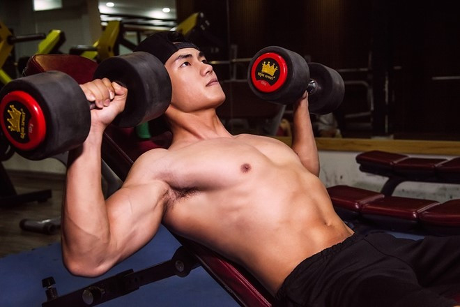 Đẩy tạ đơn trên ghế dốc: Nằm ngửa trên ghế tập tạ dốc, chân đặt trên sàn nhà, nắm tạ với độ rộng vai như hình. Thở ra khi đẩy tạ lên, siết ngực 1 giây, từ từ hít vào khi hạ xuống. Lặp lại động tác đến khi đạt yêu cầu.