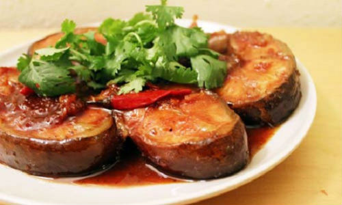 Sau đó, cho nước dừa tươi vào ngập mặt cá, nêm gia vị vừa ăn rồi kho dưới lửa nhỏ. Nước sốt sánh lại thì rắc hạt tiêu và hành lá lên trên. Ảnh minh họa: Toinayangi.