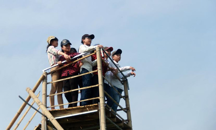 Một nhóm bạn trẻ đứng từ trên cao nhìn xuống.