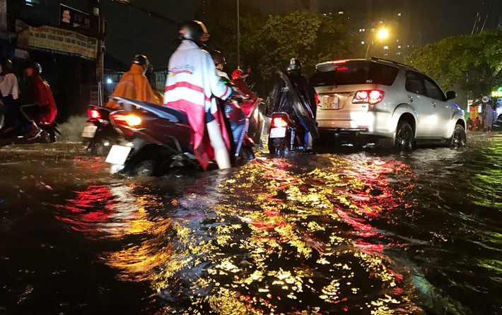 Đến tận khuya nay, người dân vẫn còn đội mưa, bì bõm lội nước để tìm đường về nhà.