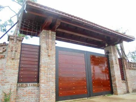 Cánh cổng được làm bằng gỗ quý dày 15cm, mái của cổng cũng được làm hoàn toàn bằng gỗ quý. Ảnh: Vietnamnet.