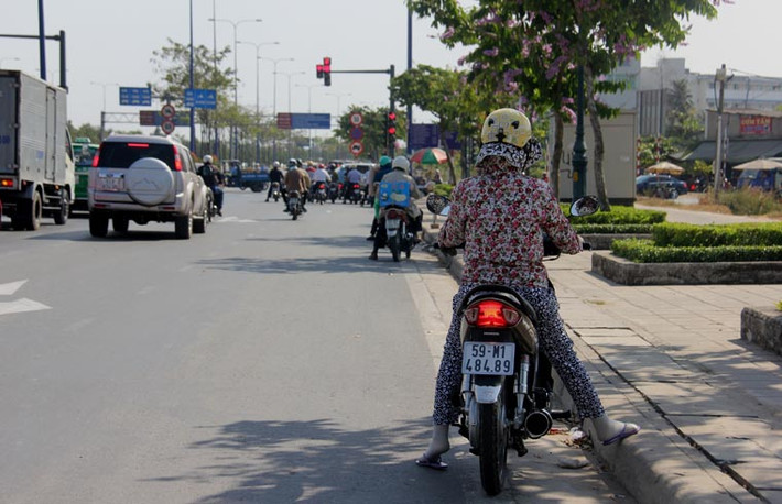 Việc dừng chờ đèn tín hiệu giữa trưa với hơi nóng tỏa lên từ nhựa đường giống như "cực hình" đối với người dân có việc phải đi lại trên đường