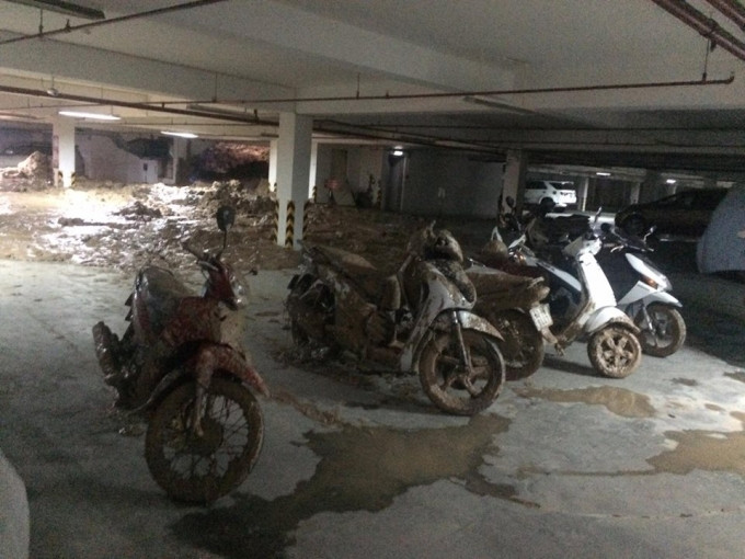 Do tường vỡ trong lúc mưa nên lượng bùn, đá, đất nhão từ công trình tràn vào tầng hầm kế bên. Lực đẩy của bùn, đất đã hất hàng chục xe máy ra nhiều mét, gần 20 xe máy đã bị chôn trong bùn, một số xe hơi bị bùn tràn vào nửa thân xe. Rất may thời điểm sập, không có người trong hầm. Ảnh: phapluatplus.vn.. Ảnh: phapluatplus.vn.