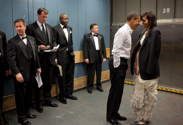 Tổng thống Obama và Đệ nhất phu nhân của mình chia sẻ một khoảnh khắc thân mật. "Không khí lúc ấy khá lạnh, vì thế Tổng thống đã khoác cho vợ chiếc áo vest ông đang mặc. Sau đó hai người đã có một chút riêng tư với nhau khi các nhân viên và đặc vụ cố gắng không nhìn", nhiếp ảnh gia Nhà Trắng Pete Souza kể lại. Ảnh: White House.