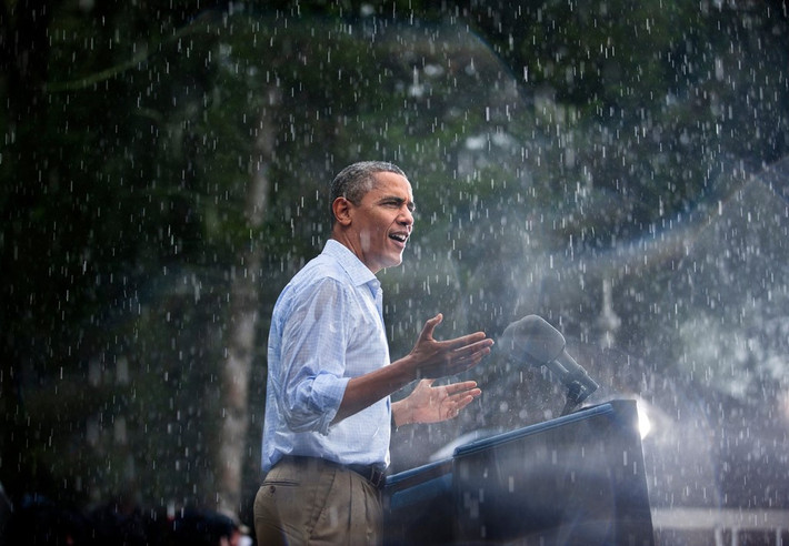 Ngày 14/7/2012, Tổng thống Obama phát biểu vận động tranh cử trong cơn mưa tại thị trấn Glen Vallen, bang Virginia. Khi đến nơi và thấy rất nhiều người đang chờ mình dưới cơn mưa rào nặng hạt, ông đã hủy buổi họp báo trong nhà và phát biểu ngay để mọi người có thể về nhà. Ảnh: Getty.