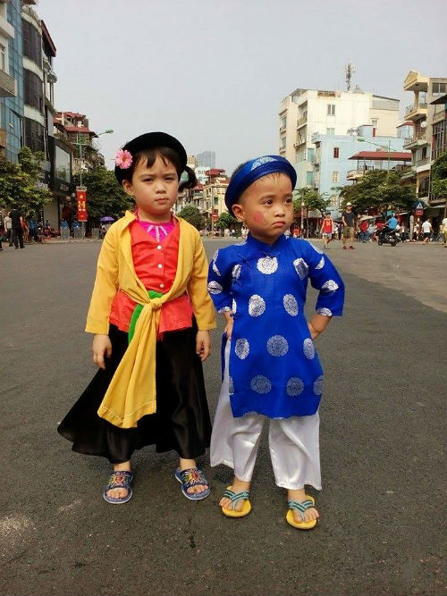 Trên nhiều tuyến phố Hà Nội, người ta gặp không ít người dân khoác lên mình tà áo dài truyền thống trong ngày lễ trọng đại Quốc khánh 2/9. Họ mặc không phải để đi biểu diễn nghệ thuật mà đơn giản vì thấy tự hào, thiêng liêng trong ngày này. Trong ảnh là 2 em nhỏ được bố mẹ cho mặc những bộ trang phục truyền thống đi xem lễ diễu binh.