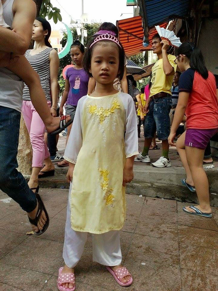 Một bé gái điệu đà với trang phục áo dài trên phố Kim Mã.