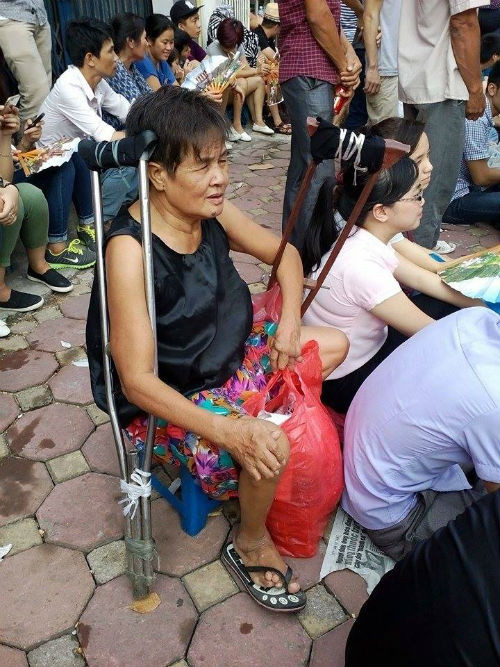 ....một số người già thì dùng ghế nhựa thấp để ngồi chờ đoàn diễu binh đi qua.