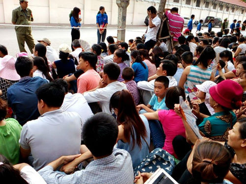 Một số đông người dân chọn cách ngồi bệt xuống đất để những người đứng sau cũng xem được hình ảnh của đoàn diễu binh.
