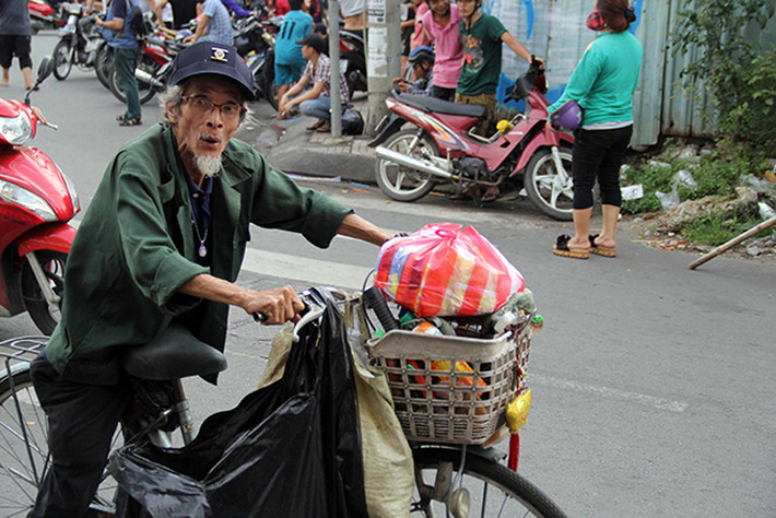 Một cụ già bán vé số hớn hở sau khi được nhận phần quà của hộ kinh doanh ở Chợ Lớn sau lễ cúng cô hồn rằm tháng 7 âm lịch.