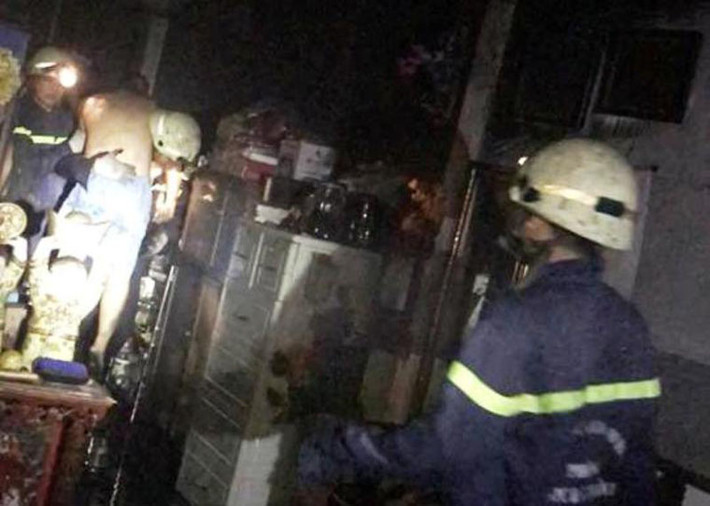 Một trong số các nạn nhân được Cảnh sát PCCC quận 11 đưa xuống từ tầng 2 căn nhà chìm trong khói lửa.