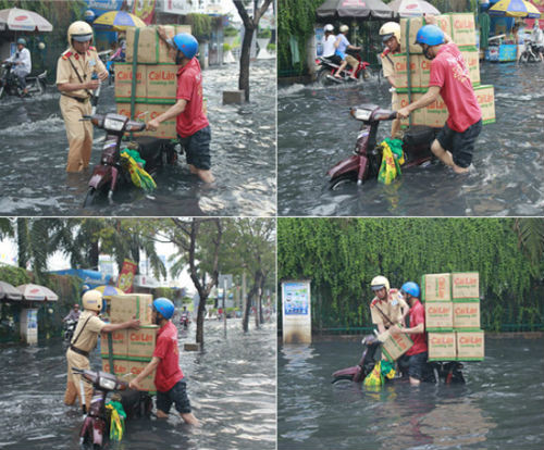Bức ảnh đã ghi lại hình ảnh đẹp của một CSGT không ngại lội trong nước ngập và phụ giúp người dân mang hàng hóa lên nơi khô ráo.