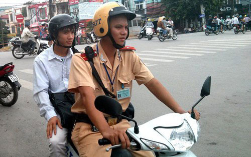 Thí sinh Phạm Văn Duy (18 tuổi, quê Thanh Hoá) được thiếu uý Lê Xuân Linh (Đội CSGT số 3, Hà Nội) dùng xe máy đưa tới điểm thi trong kỳ tuyển sinh năm 2013.