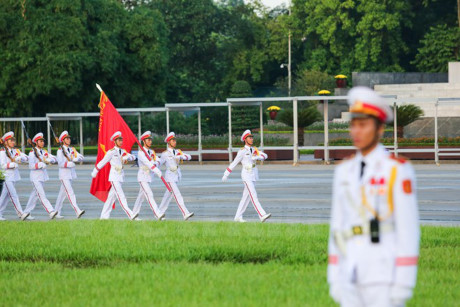 5 giờ 45, sau khi nghe tiếng báo hiệu sắp đến giờ cử hành lễ chào cờ, mọi người dân đều đứng về đúng vị trí quy định. Đoàn nghi lễ tiến ra lễ đài một cách trang nghiêm trong tiếng nhạc rộn ràng khí thế của bài Tiến bước dưới quân kỳ. (Ảnh: Minh Sơn/Vietnam+)