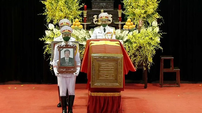 Các sĩ quan QĐND Việt Nam đang rước di ảnh, khung gắn Huân chương, Huy chương của Nguyên Tổng Bí thư Lê Khả Phiêu cùng lá Quốc kỳ di chuyển ra linh xa.