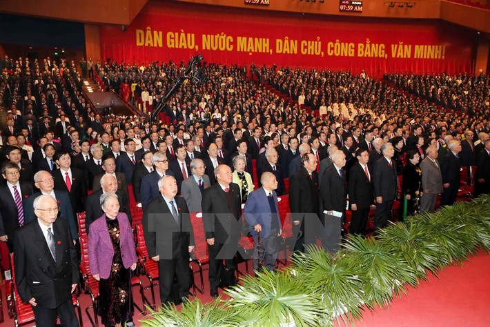 Các đại biểu dự Đại hội XII làm lễ chào cờ. (Ảnh: TTXVN)