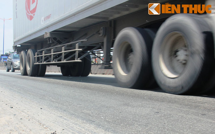 Chiếc xe đầu kéo chở thùng container đầy hàng chạy qua đoạn lún trồi nhựa trên cầu vượt thép Thủ Đức...