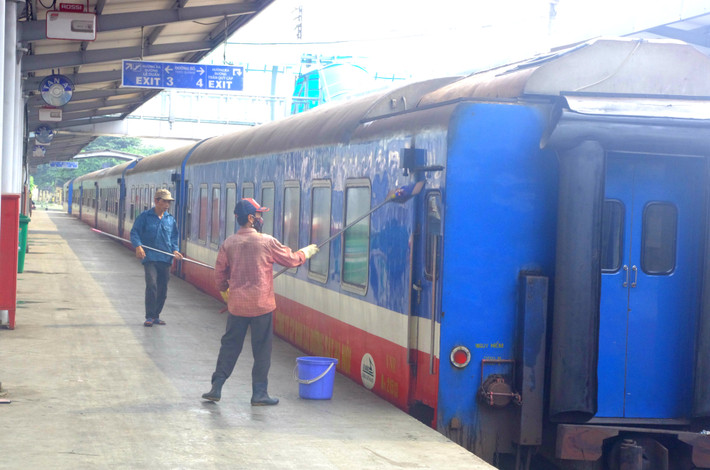 Nhân viên rửa các toa tàu của một đoàn tàu đang nằm trong nhà ga...