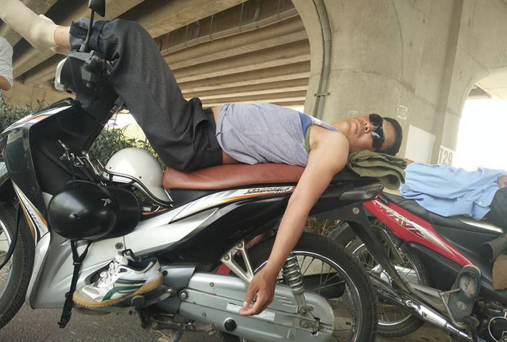 Người lao động nghèo tranh thủ trốn nắng nóng dưới gầm đường vành đai 3 trên cao (đường Phạm Hùng, Hà Nội).