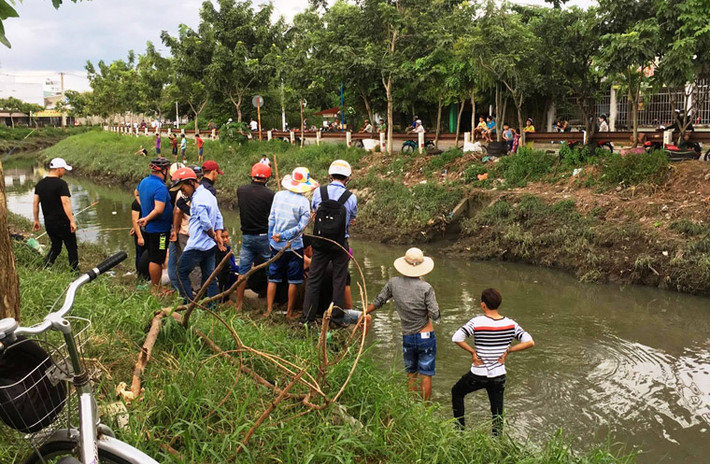 Từ chiều đến tối nay, nhiều người dân đổ ra hai khu vực bờ kênh Nước Đen ở quận Bình Tân, TP.HCM bắt cá.